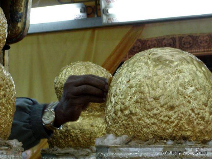 Adding gold on a reported Buddhas of the Malay Peninsula in the twelfth century by King Alaungsithu, Phaung Daw Oo Pagoda, Inle Lake - Myanmar (Burma)