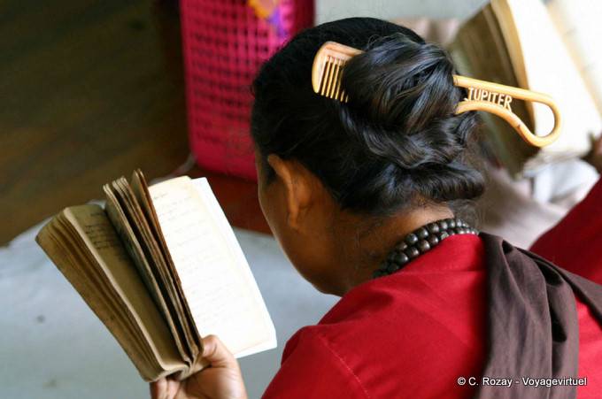 Burmese reading with a comb in hair, Mount Popa - Myanmar (Burma)