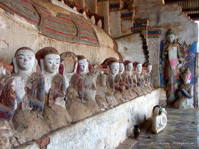 Prayer statues lined the foot of reclining Buddha, Pekhon township, Sagar - Myanmar (Burma)