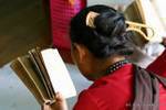 Burmese reading with a comb in hair, Mount Popa, Burma.