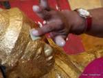 Gold leaf laid on the head of a Buddha, Rangoon, Burma.