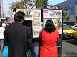 Reading newspapers on display, Lima, Peru.
