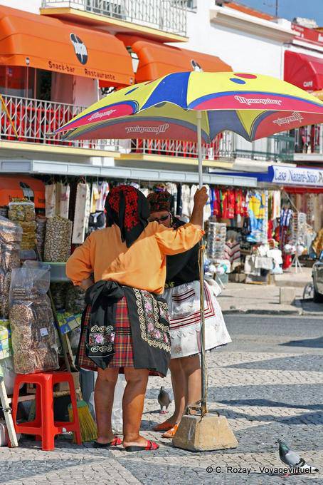 Typical costumes under the parasol, Sitio, Nazaré - Portugal