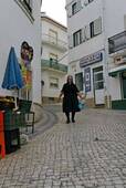The woman in black in the cobbled street, Nazaré, Portugal.