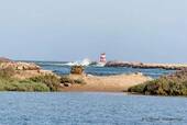Lighthouse at the mouth of estuary Formosa, Tavira, Portugal.