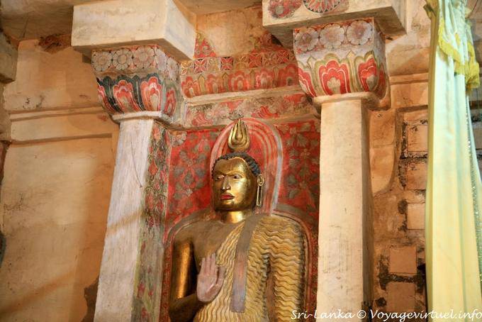 Standing Buddha forgiving on painted background, Gadaladeniya Temple, Kandy - Sri Lanka Ceylon