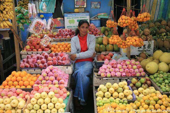 Saleswoman between apples and oranges at the market, Nuwara Eliya - Sri Lanka Ceylon
