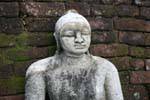 Granite Buddha bust in front of a brick wall, Medirigiriya, Sri Lanka Ceylon.