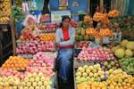 Saleswoman between apples and oranges at the market, Nuwara Eliya, Sri Lanka Ceylon.