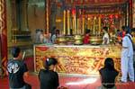 Prayer before the altar, Wat Choeng Phanan, Ayutthaya, Thailand.