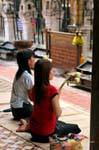Young women in prayer, Wat Phra That Lampang Luang, Thailand.