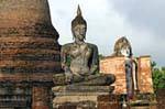 Buddha sitting in front of the Phra Attharot, Sukhothai, Wat Mahathat, Thailand.