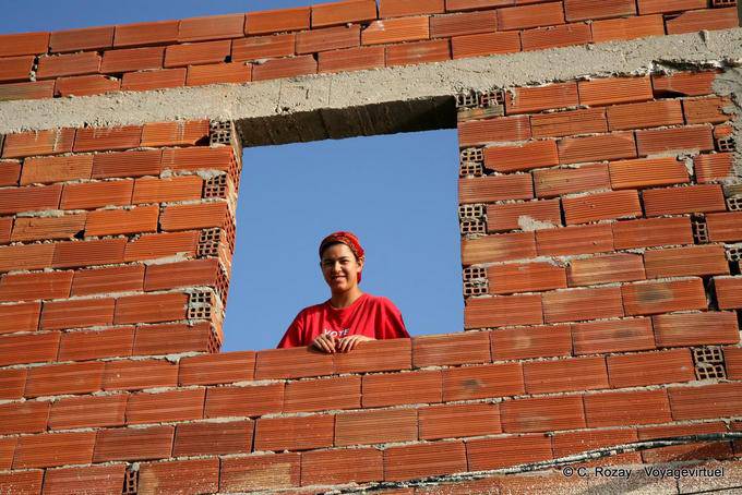Smiling woman since the construction window, Mahdia - Tunisia