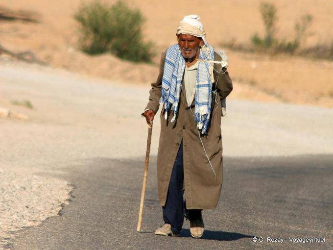 Old man walking alone on the road to Matmata - Tunisia