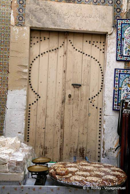 Old wooden door behind a stall treats, Sousse medina - Tunisia