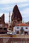 Minaret, cave dwellings and classic house, Cappadocia, Turkey.